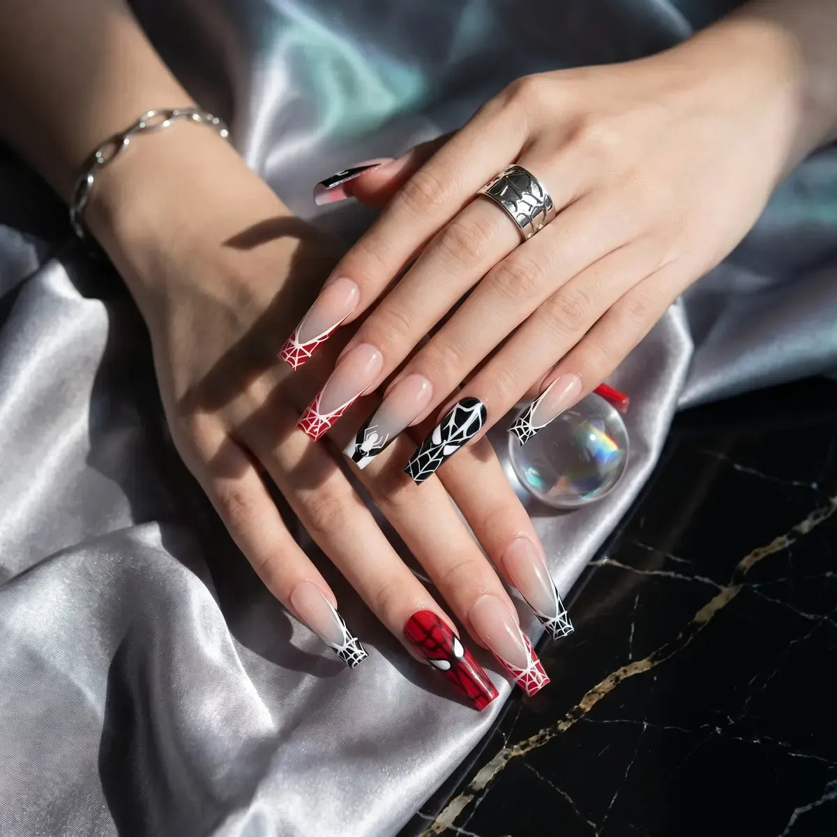 Kentrim red and black spider web superhero press on nails, 24-piece set with 12 sizes for bold nail art and easy application. Main image